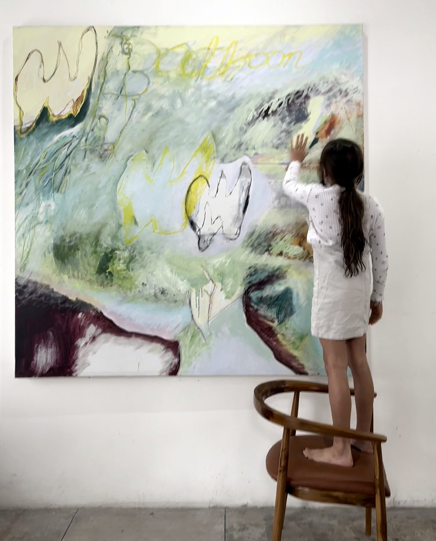 A child standing on a chair, touching Study in Release (Balloon)